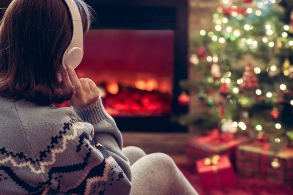 Vrouw Koptelefoon Zit Verwarmt Winters Avonds Buurt Van Open Haard — Stockfoto