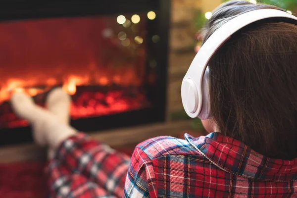 Vrouw Pyjama Hoofdtelefoon Zit Verwarmt Winters Bij Open Haard Vlam — Stockfoto