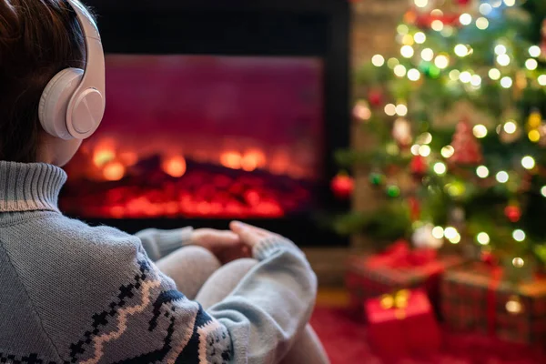 Alleen Trieste Vrouw Koptelefoon Zit Verwarmt Winters Bij Open Haard — Stockfoto