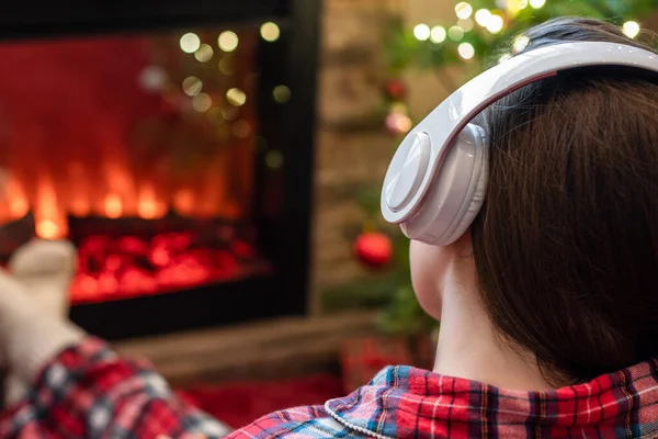 Vrouw Pyjama Hoofdtelefoon Zit Verwarmt Winters Bij Open Haard Vlam — Stockfoto