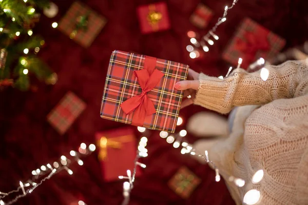 Wanita Tangan Mengulurkan Kotak Hadiah Melalui Karangan Bunga Bercahaya Natal — Stok Foto