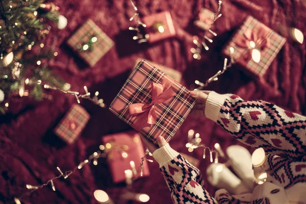 Mano Mujer Sosteniendo Caja Regalo Través Guirnalda Brillante Navidad Vista —  Fotos de Stock