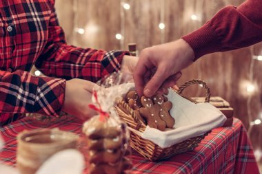 Adam müşteri noel adamı zencefilli ekmeği alıyor, pastanede şekerleri tezgahın üzerinde saman sepetinde yatıyor. Götürün..