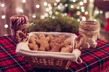 Zencefilli çörek adam, marşmelov, masanın üstünde şekerlemeler Noel ağacı arka planında güzel bir ışık var..
