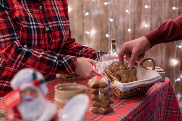 Man  customer buying christmas man gingerbread, sweets at the bakery lying in a straw basket on the counter. Take away.