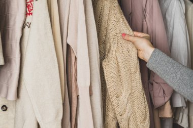 Kadın müşteri kumaşı kontrol ediyor. Yünlü süveter seçiyor. Alışveriş.