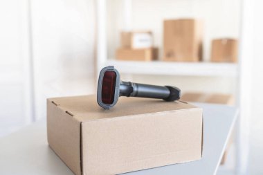 Postanenin kadın çalışanı. Müşteri gönderdiğini onaylamak için barkod tarayıcısı kullanıyor. Ev teslimat servisi.