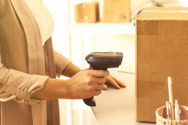 Barkod tarayıcı, perakende teslimat paketini tarayan posta koduyla küçük bir iş kuran kadın sahibi. Depo çalışanı.