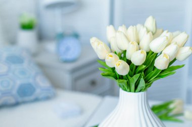 Oturma odasındaki sehpanın üstünde beyaz vazodaki laleler çiçek açıyor. Buket besteliyorum. Durgun hayat