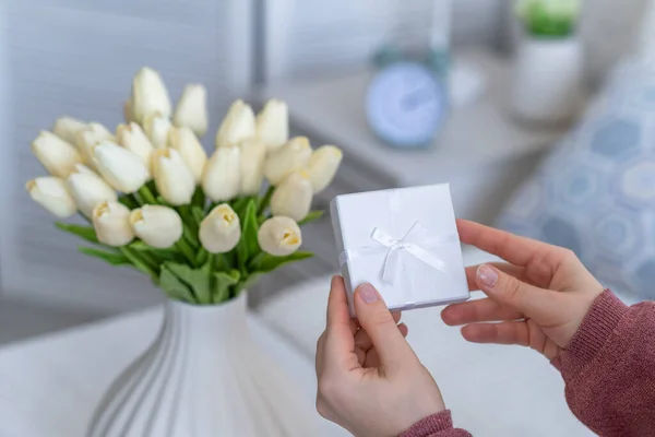 Kezében Kis Fehér Ajándék Doboz Ékszerek Csokor Fehér Tulipán Virágok — Stock Fotó