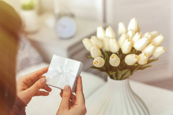 Kezében Kis Fehér Ajándék Doboz Üdvözlőlapot Csokor Fehér Tulipán Virágok — Stock Fotó