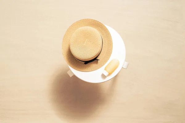 防晒霜用于保护沙滩上白色桌子上的皮肤和草帽 顶部视图 — 图库照片