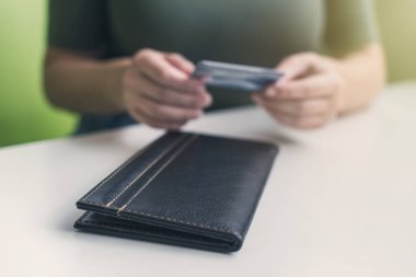 Kafe masasında elinde dosya ve fatura olan kadın eli resmi var. Restoran ziyaretçisi kredi kartıyla ödemeye hazır.