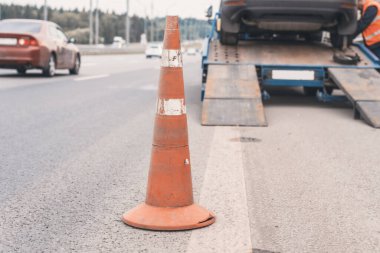 Yoldaki trafik konilerinin dikkatine. Seçici odaklanma. Çekici yolda bozuk bir arabayı çekiyor.