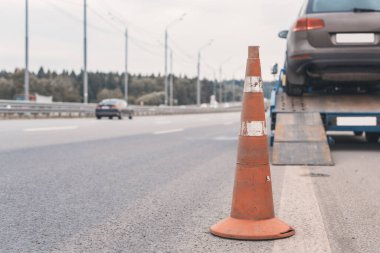 Yoldaki trafik konilerinin dikkatine. Seçici odaklanma. Çekici yolda bozuk bir arabayı çekiyor.