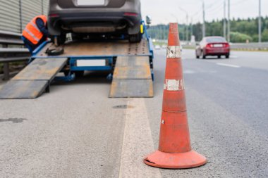 Yoldaki trafik konilerinin dikkatine. Seçici odaklanma. Çekici yolda bozuk bir arabayı çekiyor.