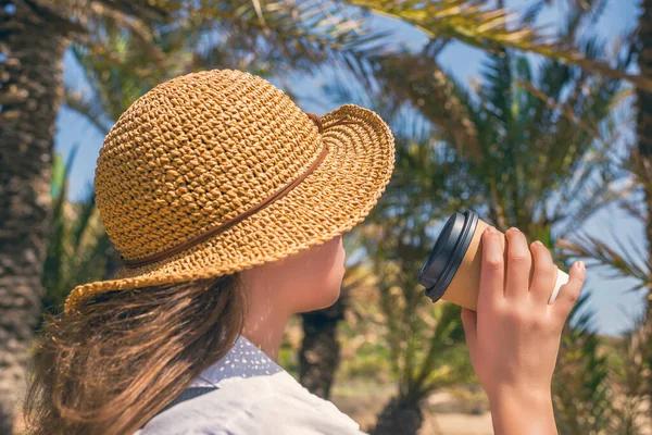 Pohled Zezadu Ženu Slamáku Papírovým Šálkem Kávy Kráčející Palmovém Lese — Stock fotografie