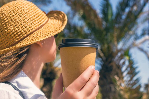 Вид Сзади Женщину Соломенной Шляпе Бумажной Чашкой Кофе Прогуливаясь Пальмовому — стоковое фото