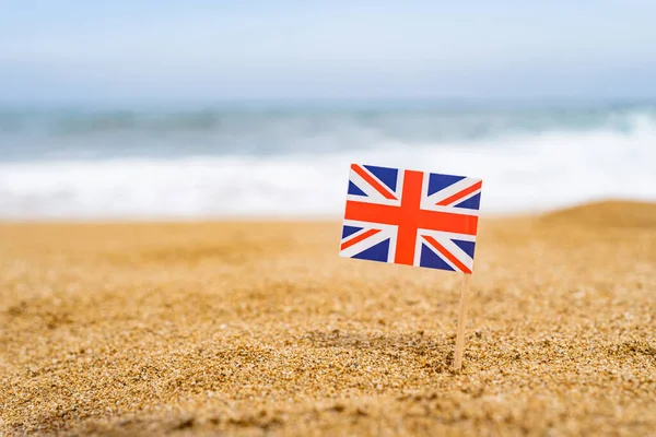 Flagga Storbritannien Form Tandpetare Sanden Stranden Mittemot Havsvåg Resebegrepp — Stockfoto