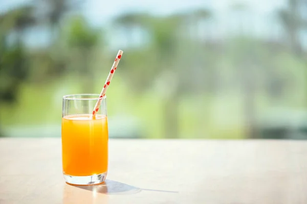 棕榈树森林里桌子上的橙汁 — 图库照片