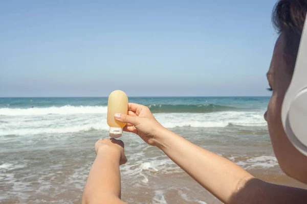 Woman Headphones Listen Music Applying Sunscreen Skin Beach Looking Sea — Stock Photo, Image