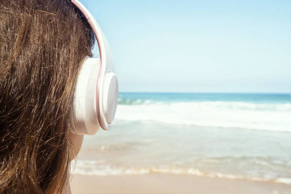 Visão Traseira Uma Mulher Sozinha Sentada Uma Praia Com Fones — Fotografia de Stock