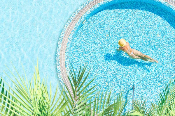 아름다운 여자가 비키니 모자를 야자수로 수영장에서 수영을 공중에서 위에서는 시야에 — 스톡 사진