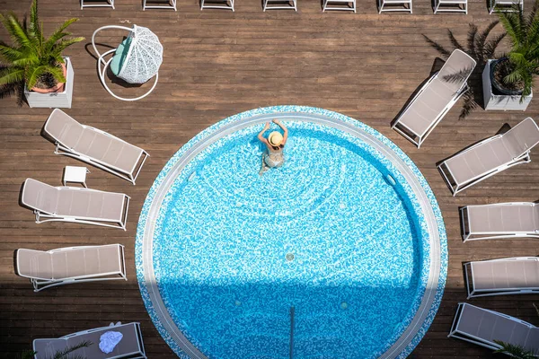 穿着比基尼和帽子的年轻漂亮的女运动员穿着夹克衫在木制露台上游泳 从上方俯瞰空中无人机 热带夏季豪华酒店 — 图库照片