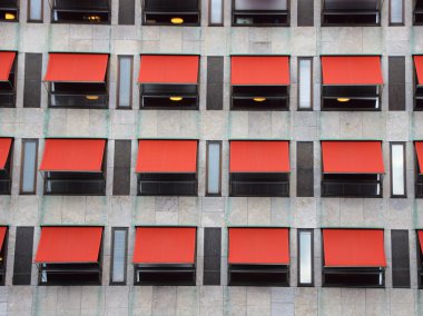 Twelve Red Sunshades on Modern Building Facade clipart