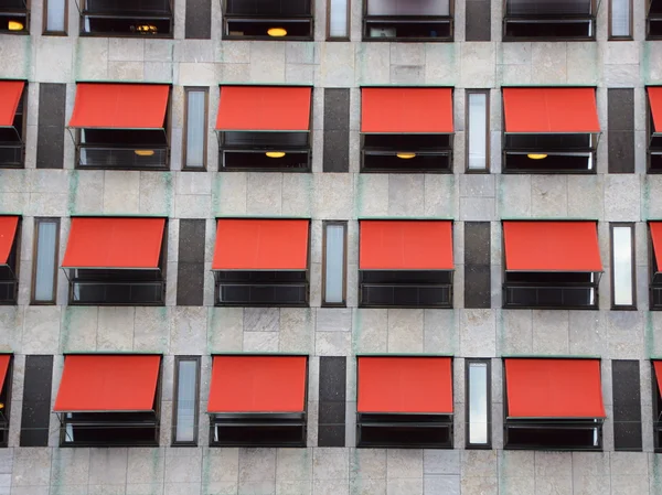 Doce sombrillas rojas en la fachada del edificio moderno Imágenes de stock libres de derechos