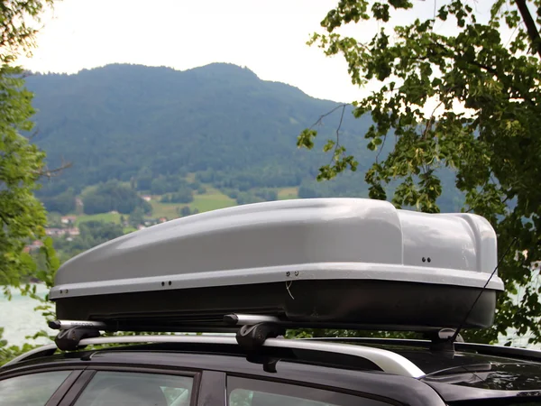 Auton matkatavaroiden laatikko Mountain ja järvi taustalla — kuvapankkivalokuva