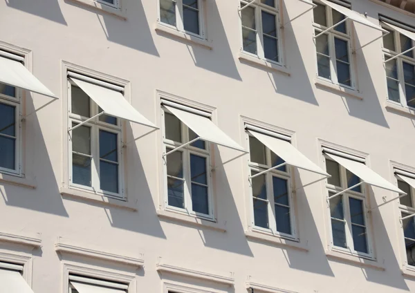 Closeup perspective on grey building with  white awning — Stock Photo, Image