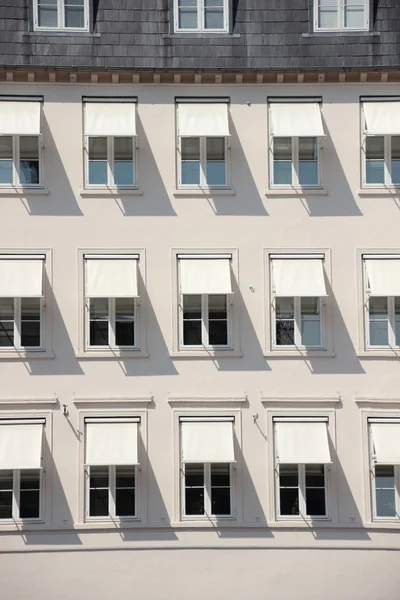 Gevel van grijze gebouw met witte luifel en schaduw — Stockfoto