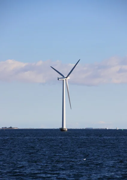 Einzelne Meereswindmühle mit dunkelblauem Wasser und Wolken — Stockfoto