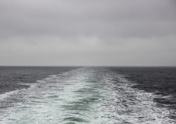 Ship water trace and trail with cloudy horizon — Stock Photo, Image