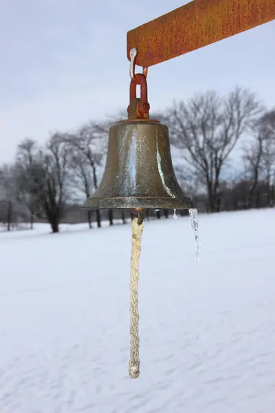 Campana in metallo con campi innevati invernali sullo sfondo — Foto Stock