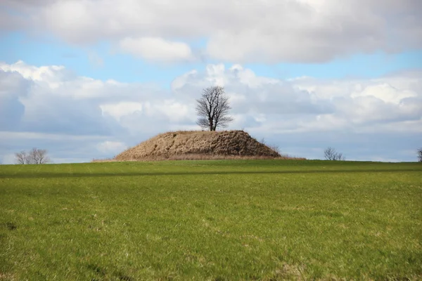 Oude grafheuvel heuvel met dramatische wolken — Stockfoto