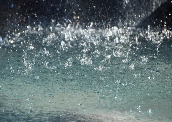 Resumen de las gotas de lluvia en el fondo sobre la superficie del agua — Foto de Stock