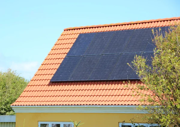 赤タイルの家の屋根に太陽電池パネル — ストック写真
