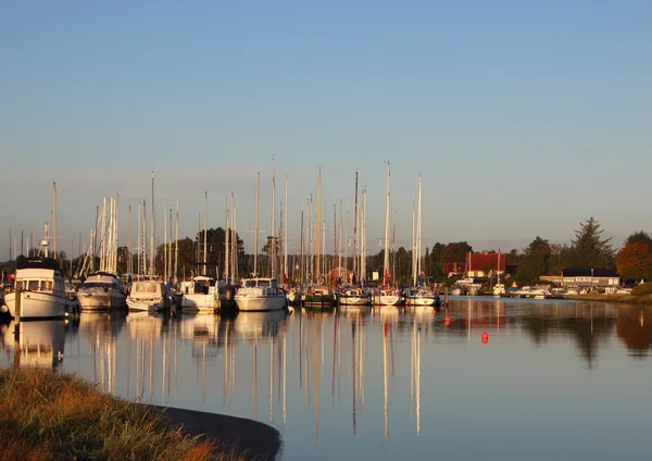 Yachts à voile dans un petit port avec des reflets dans l'eau — Photo