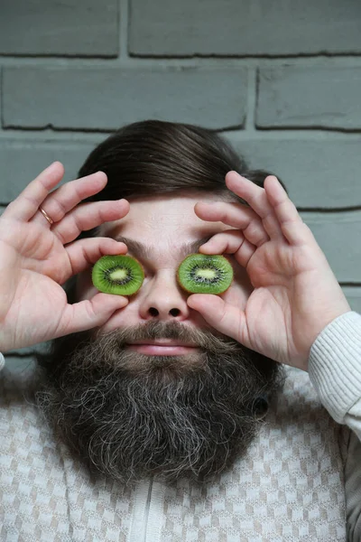 Un hombre barbudo con un kiwi en los ojos — Foto de Stock