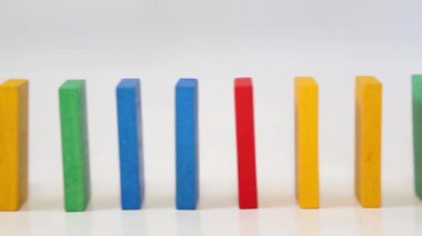 Sıraya dizilmiş renkli tahta dominolar. Yan görüş. Renkli tahta bloklar. Denge kavramı