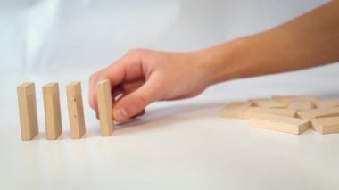 Oğlan tahta dominoları sıraya dizdi. Dikkatsiz hareket - her şey düştü.