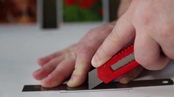 The mans hands carefully cut out a magnet with a knife. Close-up. Handmade work — Vídeo de stock