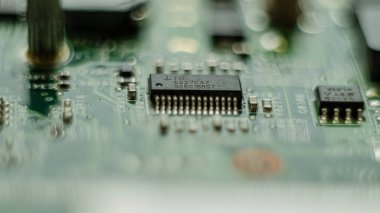Karmaşık elektronikler, mikro kontrollü yeşil devre kartı, ortasında mikro işlemci kontrol çipi, aşırı yakın çekim detay makrosu, teknoloji mühendisliği soyut devreler endüstriyel arka plan