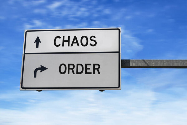 Road sign with words chaos and order. White two street signs with arrow on metal pole on blue sky background.