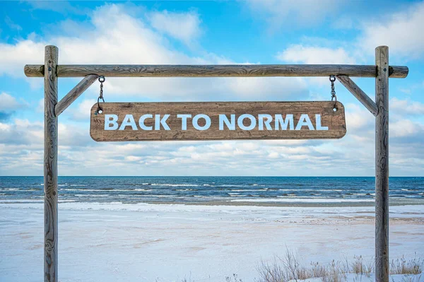 在蓝天 沙滩和白沙的映衬下 用文字回到正常的木制标志 旅行和休假概念 — 图库照片