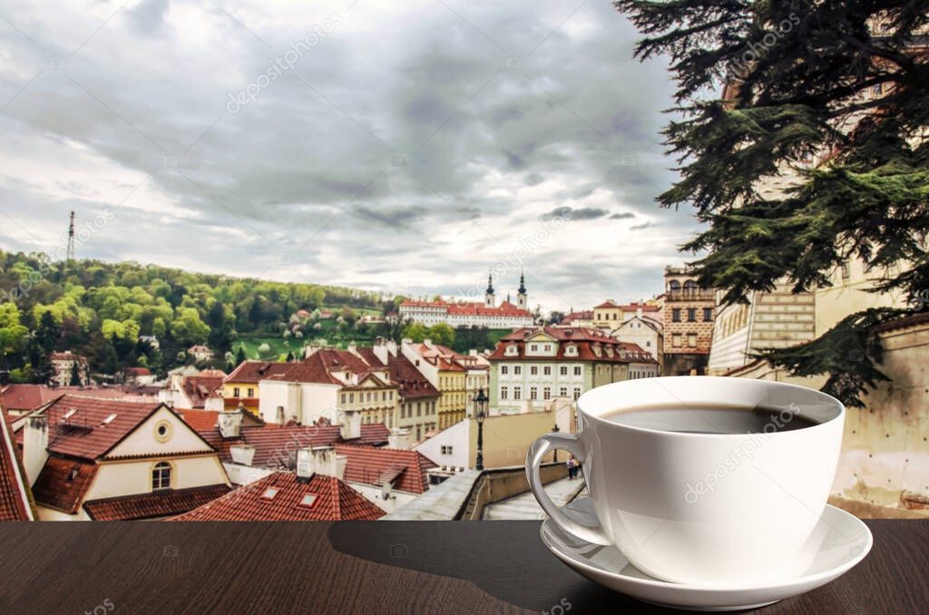 Cup of hot black coffee in cafe with view of street in Prague, Czech Republic. Street with beautiful view on historic downtown in Prague.