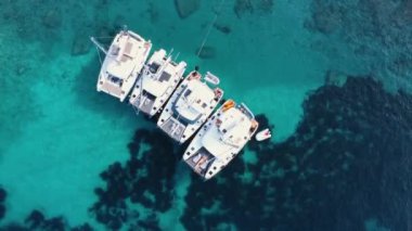 Kristal şeffaf mavi su üzerinde küçük teknelerin yukarıdan aşağı görüntüsü.