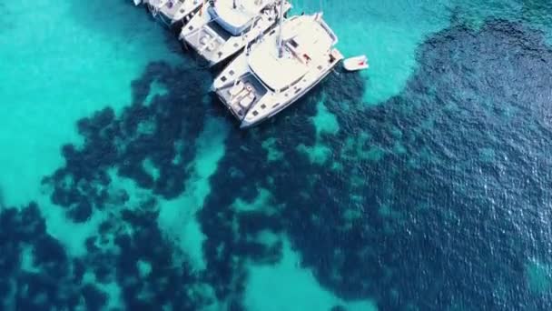 Vista de arriba hacia abajo de pequeñas embarcaciones en agua azul translúcida cristalina. — Vídeos de Stock